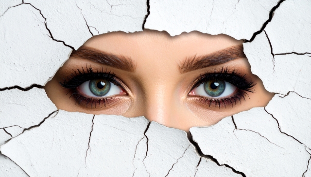 壁の割れ目から覗く目