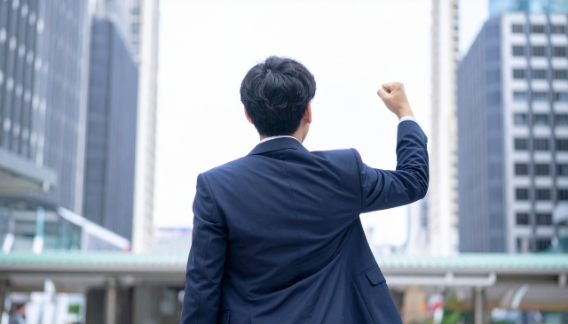 片手のこぶしを握るビジネスマン